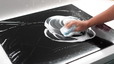 Cleaning Black Induction Cooktop with Sponge and Foam Close Up 動画素材 341575455