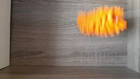 Cleaning the bookshelf from dust using an orange microfiber duster. Stock Footage 289452530