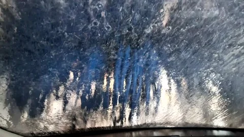 Cleaning a car in an automatic car wash tunnel Stock Footage 256184074