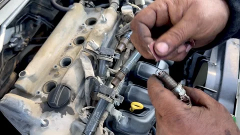 Cleaning a car engine spark plug with sandpaper in car garage. Stock Footage 264253192