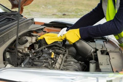 Cleaning the car engine with a yellow microfiber cloth and a professional det Stock Photos