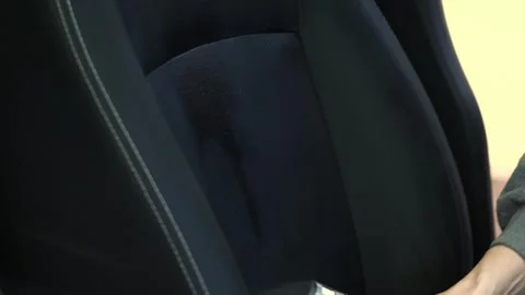 Cleaning car seats with a hand held wet vacuum inside a garage Video stock 333682966