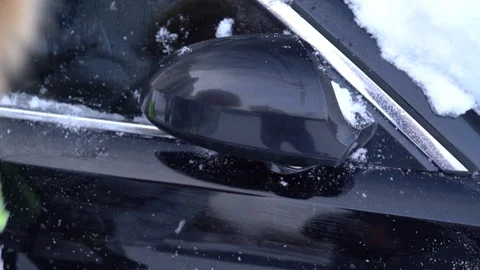 Cleaning the car of snow after snowfall Stock Footage 100876809