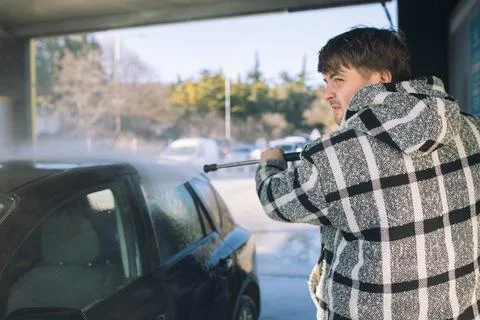 Cleaning car using active foam. Man washing his car on self car-washing. Stock Photos