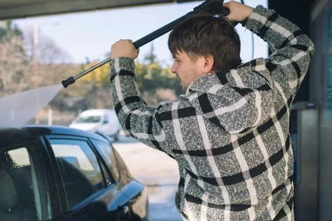 Cleaning car using active foam. Man washing his car on self car-washing. Stock Photos
