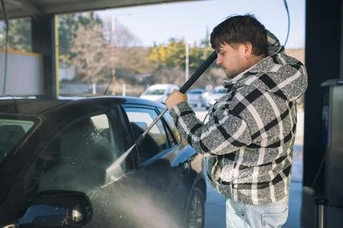 Cleaning car using active foam. Man washing his car on self car-washing. Foto stock