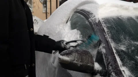 Cleaning a car window from snow with a brush. Winter in Russia, the car was Stock Footage 145772502