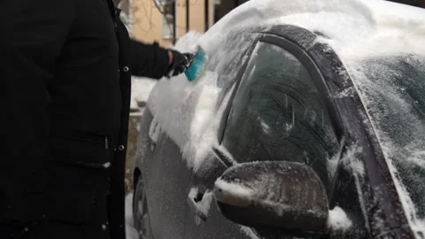 Cleaning a car window from snow with a brush. Winter in Russia, the car was Stock Footage 145772658