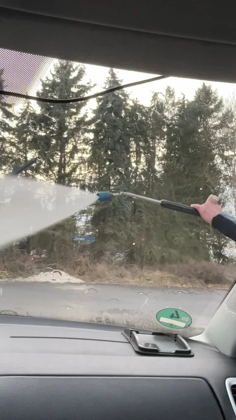 Cleaning car windshield with high-pressure water Stock Footage 303383100