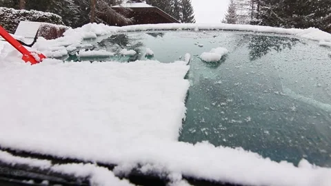 Cleaning car windshield on the snowfall Stock Footage 295416380