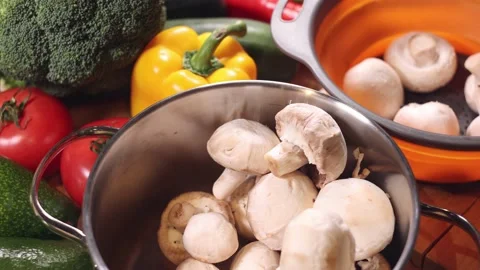 Cleaning champignons on a table full of vegetables. Stock-Footage 144022065