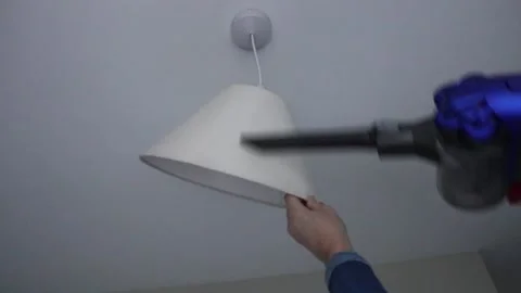 Cleaning chores in the home dusting ceiling light and shade Video stock 146446640