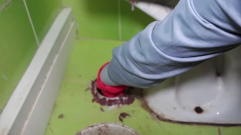 Cleaning clogged drain hole under toilet with hand Stock-Footage 331781007