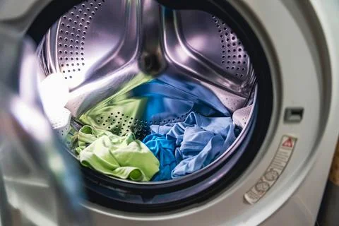Cleaning clothes in a washing machine during a laundry day in a home setting Foto stock