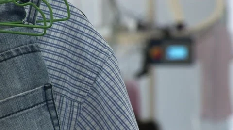 Cleaning company rack focus between clothes and conveyeur Stock Footage 42329803