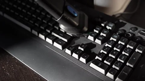 Cleaning a computer keyboard using a vacuum cleaner in a home office setting Stock Footage 331847450