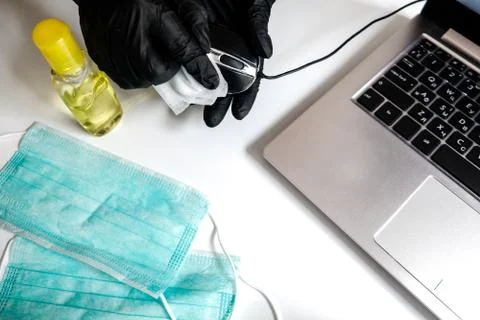 Cleaning a computer mouse to prevent bacteria and virus spreading in isolation Stock Photos