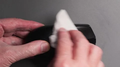 Cleaning a computer mouse with a wet wipe Stockbeeldmateriaal 347193282