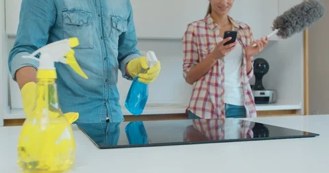 Cleaning cooktop cooking panel in kitchen with fat remover spray and a duster by Stock Footage 115350981