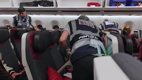 Cleaning crew attends to aircraft interior after passenger incident Vídeos de archivo 310071738