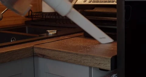 Cleaning crumbs from the kitchen table with a vacuum cleaner Stock Footage 264584816