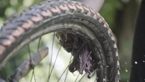 Cleaning cycle tyre being washed with water slow motion  washing bicycle kids Video stock 129927671