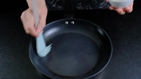 Cleaning a Dark Gray Frying Pan with Brush in Kitchen Cooking Scene Stock Footage 341420728