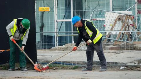 Cleaning debris workers in helmets on construction site Stock-Fotos