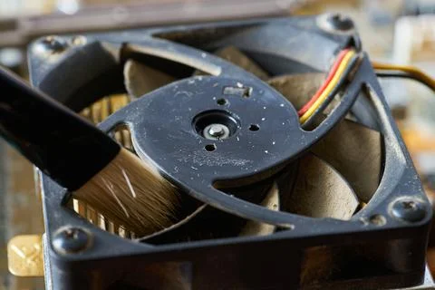 Cleaning dirty desktop computer processor fan from dust by special brush clos 写真素材