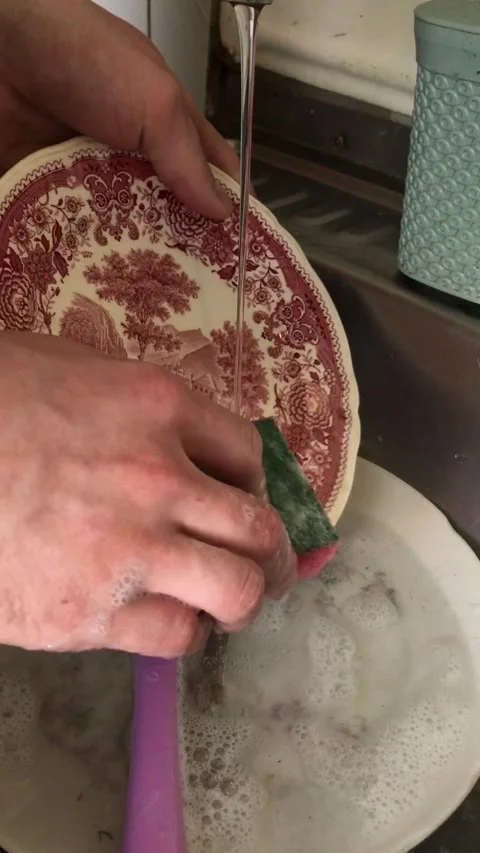 Cleaning dishes in an old-style kitchen with running water Stock Footage 308368188