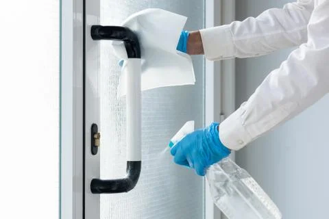 Cleaning the door handle with alcoholic solution for coronavirus disinfection Stock Photos