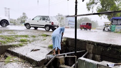 Cleaning of Drain During Heavy Rainfall Stock Footage 332761330