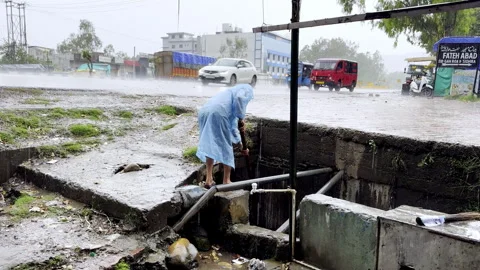 Cleaning of Drain During Heavy Rainfall Stock Footage 332761340