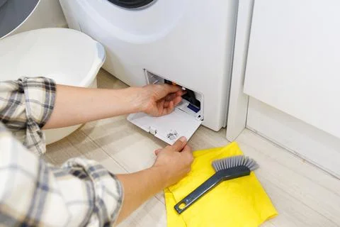 Cleaning the drain filter of a washing machine to remove dirt and buildup. Stock Photos