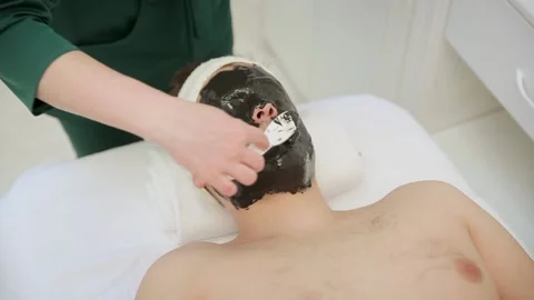 Cleaning face skin with spa cleansing mud. Male skincare beauty treatment Stock Footage 131335007