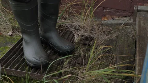 Cleaning feet in rubber boots Stock Footage 342865630