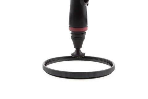 Cleaning a filter of camera with a tool Stock Photos