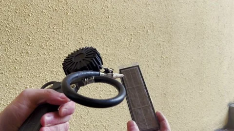 Cleaning the filter from a robot vacuum cleaner under high pressure. 库存影片 169865316