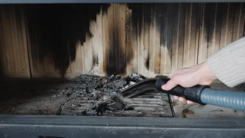 Cleaning fireplace ashes with vacuum cleaner hose during daytime. Stock Footage 334830203