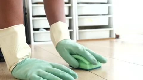 Cleaning a floor with gloves and a sponge in a bright room Stock Footage 345696031