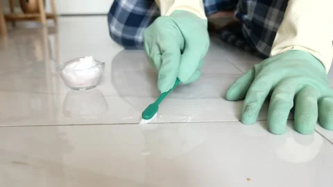 Cleaning floor tiles with a brush and baking soda Stock Footage 343045559