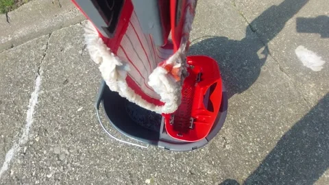 Cleaning floor - wringing a modern flat mop in a red bucket, top view Stock Footage 333643924