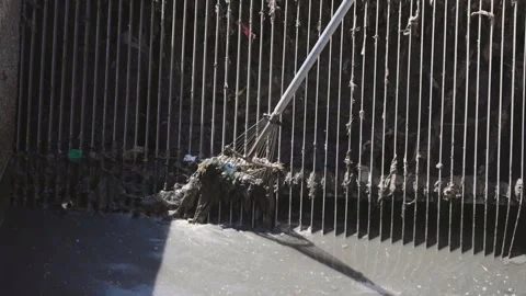 Cleaning garbage from a drainage grate in a wastewater treatment process Stock Footage 312871537