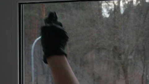 Cleaning the glass surface of the window with a scraper. Female hand close-up. Vídeos de archivo 235930568
