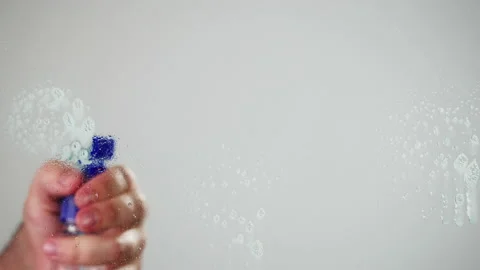 Cleaning glass, using spray detergent on grey chroma key background. Spring Stock Footage 182018183