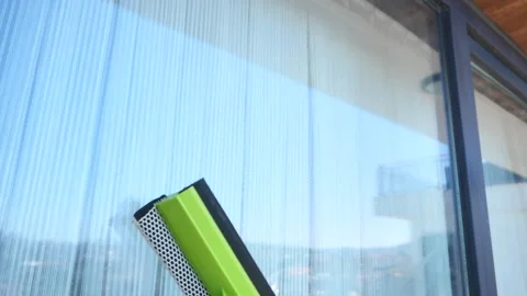 Cleaning glass windows with a squeegee for a clear view Stock Footage 317067090