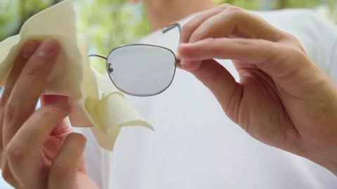 Cleaning glasses with white cloth. Macro of a person with a white microfibe.. Stock-Footage 339528645