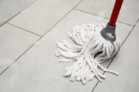 Cleaning grey tiled floor with string mop, space for text Stock Photos