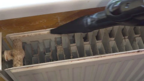 Cleaning the heating radiator with a vacuum cleaner Stock Footage 340750026