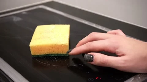 Cleaning the hob with a sponge Stock Footage 229377029